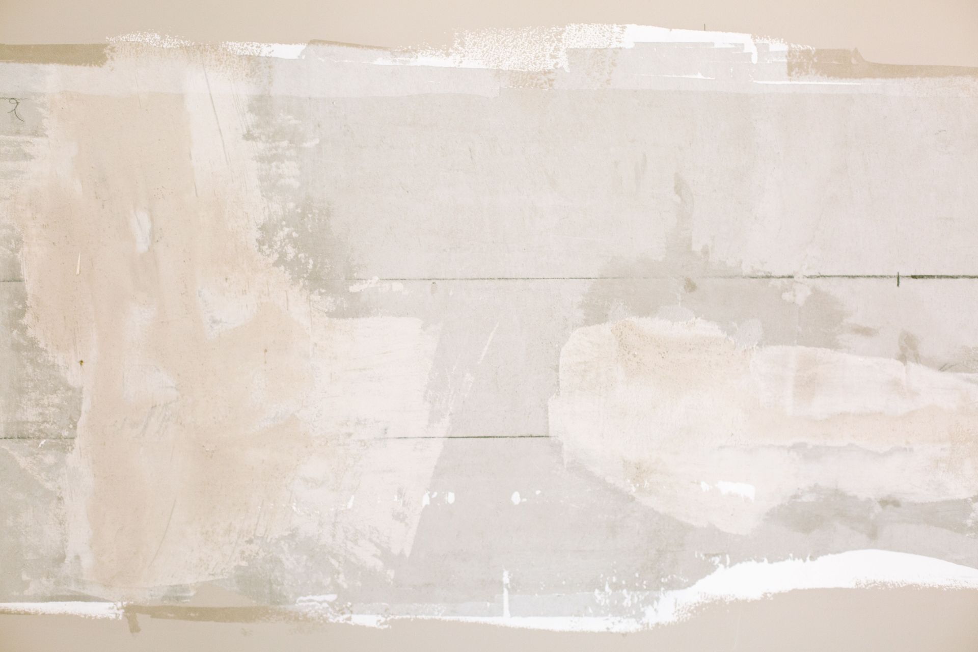 Close-up of an unfinished wall showing plaster and paint textures in a home renovation.